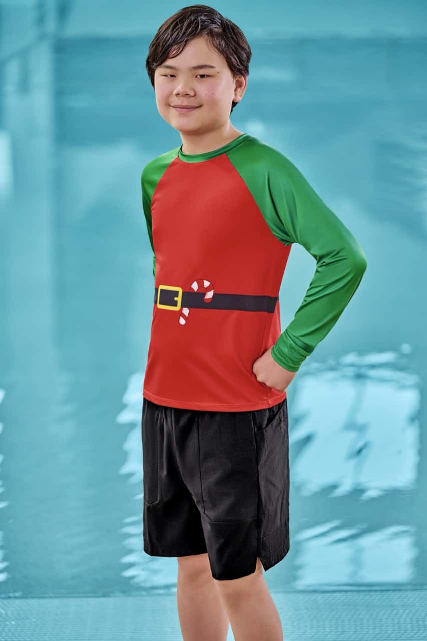 a boy wearing a holiday themed elf swimwear